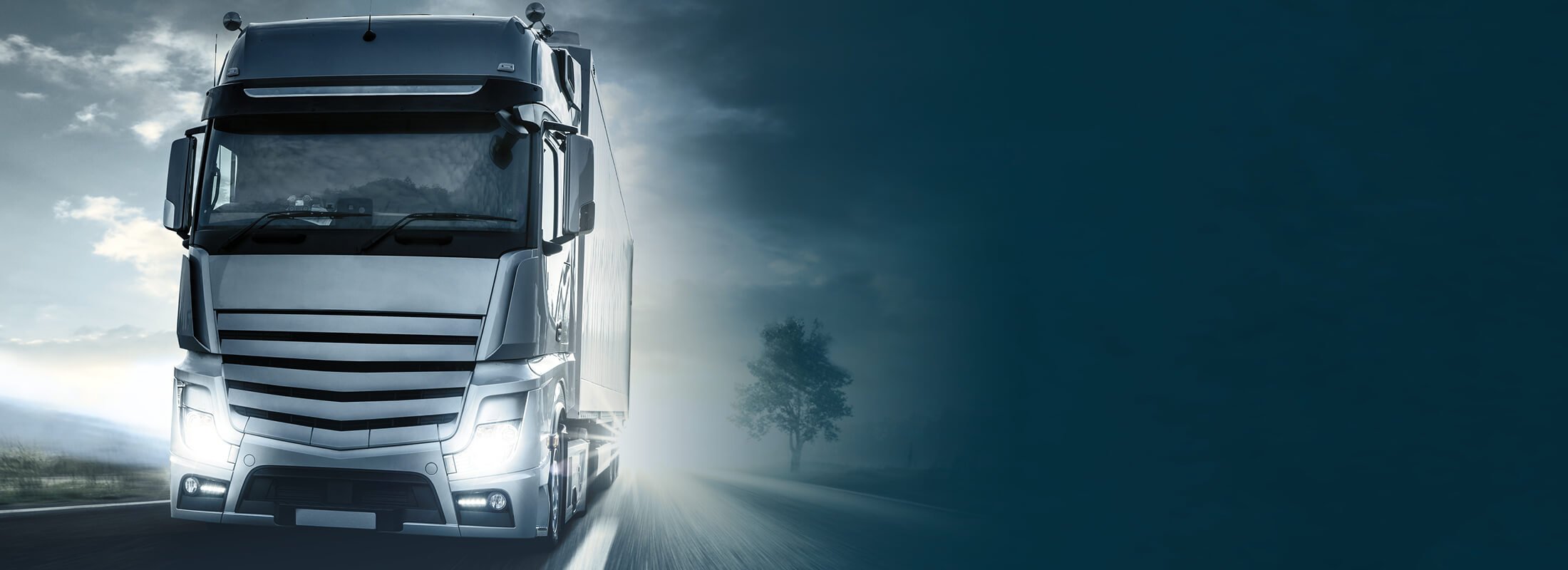 Ein LKW mit eingeschalteten Scheinwerfern.