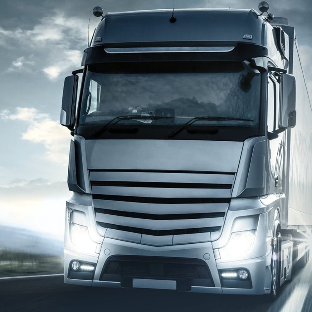 LKW mit eingeschalteten Scheinwerfern.