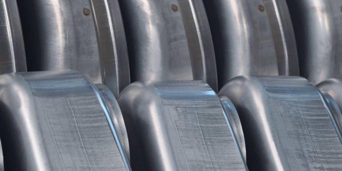 Several workpieces of metal lined up, in a close view.