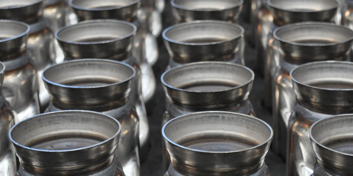 Mehrere identische Werkstücke aus Metall aufgereiht.
